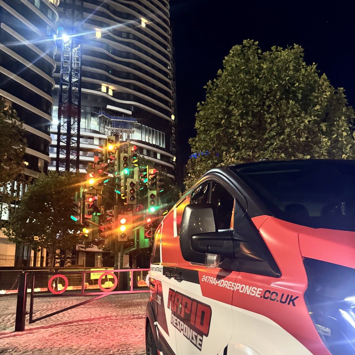 247 Rapid Response branded van at a London traffic-light cluster at night